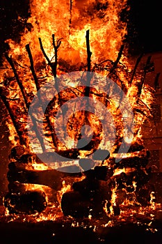 amazing violent bonfire of fire in a village in the dark night. The combustion of firewood creates big flames, flares, smoke, gas photo