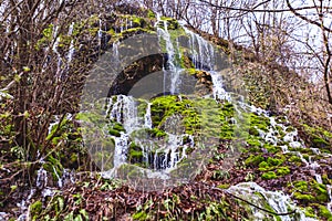 Amazing waterfall stream in forest, early spring. Nature landscape. Waterfall Siga. Homolje mountains photo