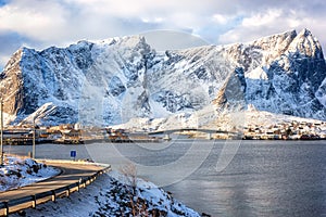 Amazing winter landscape, Lofoten Islands, Hamnoy, Norway. Scenic view of the snowy rocky mountains, water and blue sky with cloud