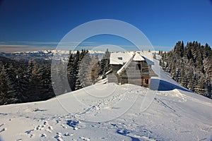 Amazing winter landscape in the mountains with old wood cottage
