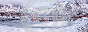 Amazing winter landscape, snowy mountains, fjord with fishing boats, Lofoten Islands. Outdoor travel background