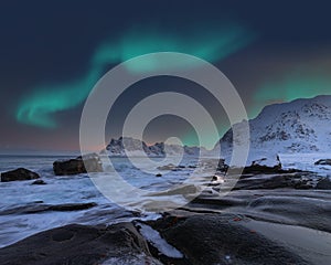 Amazing winter scenery on Uttakleiv beachat night with Northern lights