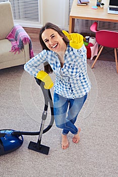 Amazing woman holding vacuum cleaner and showing clearness of ca