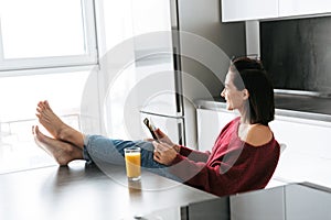 Amazing woman indoors in home at the kitchen using tablet computer