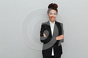 Amazing young african business woman standing over grey wall