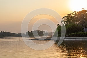 Amazon rainforest sunset during a boat trip with a reflection of the trees in the water. Puerto Francisco de Orellana. Ecuador.