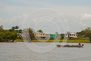 Amazon river, Amazonas, Brazil: Fisherman dancing on the boat. Wooden local huts, houses on the Amazon river in Brazil