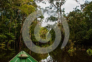 Amazon river, Manaus, Amazonas, Brazil: Wooden boat floating on the Amazon river in the backwaters of the Amazon jungle