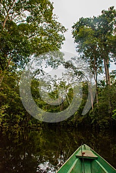 Amazon river, Manaus, Amazonas, Brazil: Wooden boat floating on the Amazon river in the backwaters of the Amazon jungle