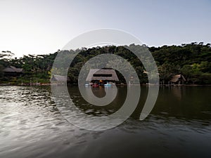 Amazon tropical rainforest exotic lush jungle eco lodge hotel wooden cabin stilt hut at river lake in South America