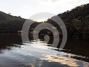 Amazon tropical rainforest exotic lush jungle eco lodge hotel wooden cabin stilt hut at river lake in South America