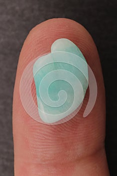 Amazonite jewel stone texture on the finger