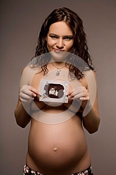 Ambarrassed pregnant woman with a sonogram photo