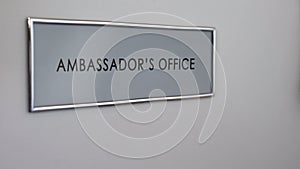 Ambassador office door, hand knocking closeup, visa consultation service, work