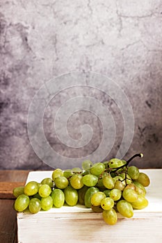 Amber bunch of grapes on a gray concrete background.