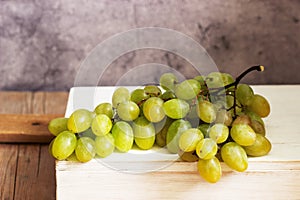 Amber bunch of grapes on a gray concrete background