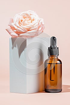 Amber cosmetic bottle with pipette on white podium, product packaging, anti aging serum with peptides, cosmetics mockup