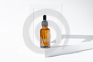 Amber cosmetic bottle with pipette on white podium, product packaging, anti aging serum with peptides, cosmetics mockup, spa