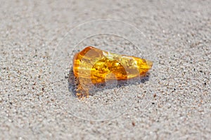 Amber with inclusions on sand photo