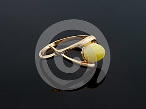 Amber jewelry gold ring. Baltic amber. Black background.
