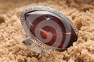 Amber ring in sand