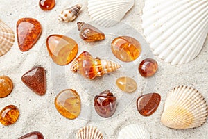 Ambers and Seashells on Sand Background Flat Lay Top View