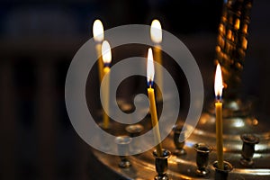 Ambiance of church, light of candles. Candles in a church. Light of candles in the church on the dark background