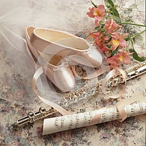 Ambience shot of ballet pointe shoes, flute and flowers