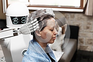 Ambient assisted living household robot is washing the hair of an adult woman photo