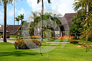 Paisagismo tropical com jardins, construÃÂ§ÃÂµes coloridas ao fundo cercadas por muita vegetaÃÂ§ÃÂ£o photo