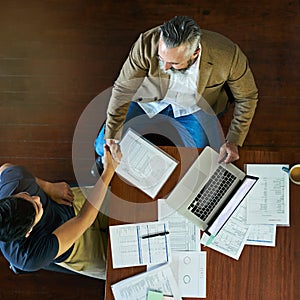 Ambition makes things happen. High angle shot of two businessmen shaking hands in an office.