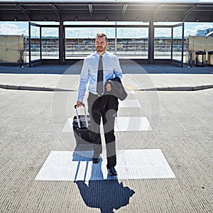 Ambition will take you places. a professional businessman walking toward an airport with his luggage.