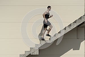 Ambitions concept with sportsman climbing stairs photo