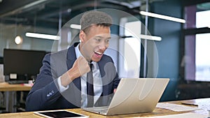 Ambitious businessman celebrating success on laptop