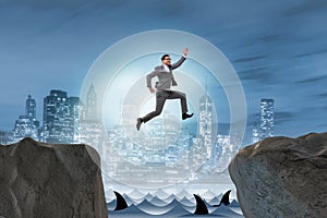 The ambitious businessman jumping over the cliff