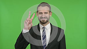 Ambitious Businessman Showing Victory Sign against Chroma Key