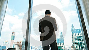 Ambitious businessman standing in ornamented office on cityscappe background