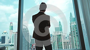 Ambitious businessman standing in ornamented office on cityscappe background