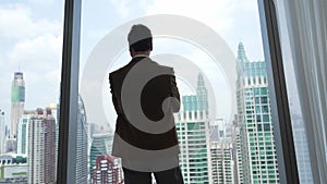 Ambitious businessman standing in ornamented office on cityscappe background