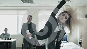 An ambitious businesswoman is dancing freely in the office. A young blonde feminist takes power in the office with the