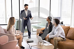 Ambitious confident young boss talking to diverse team