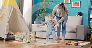 Ambitious mother devotes a lot of time to son, they play with toys in the