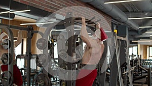 Ambitious santa man having workout in fitness center. Sportsman doing pullups