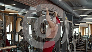 Ambitious santa man having workout in fitness center. Sportsman doing pullups