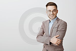 Ambitious smart and intelligent good-looking european male entrepreneur in glasses and stylish jacket crossing hands on