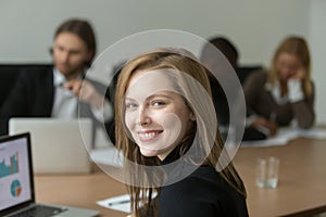 Ambitious smiling young businesswoman at team meeting, head shot