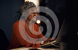 The ambitious always succeed big. a young businesswoman working on a laptop in an office at night.