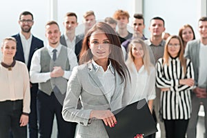 Ambitious young business woman standing in front of her colleagues