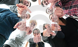 Ambitious young people standing in a circle and pointing at you.