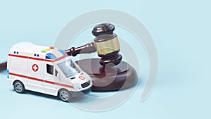 Ambulance car and brown gavel stethoscope and on a blue background. symbol photo for bungling and medical error